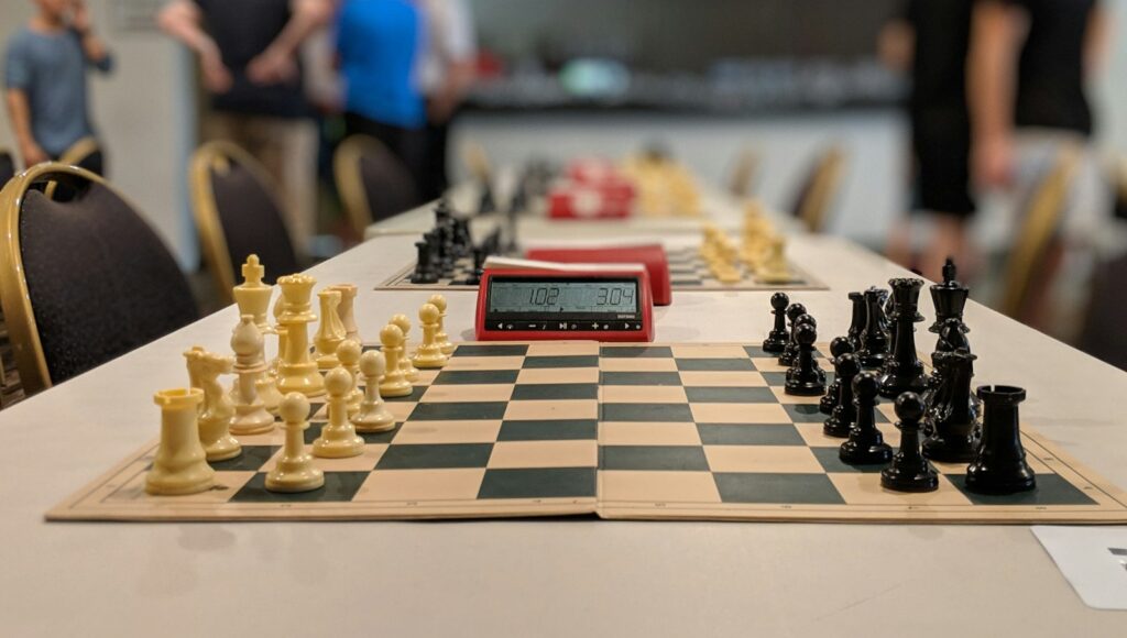 black and white chess board near people standing inside building