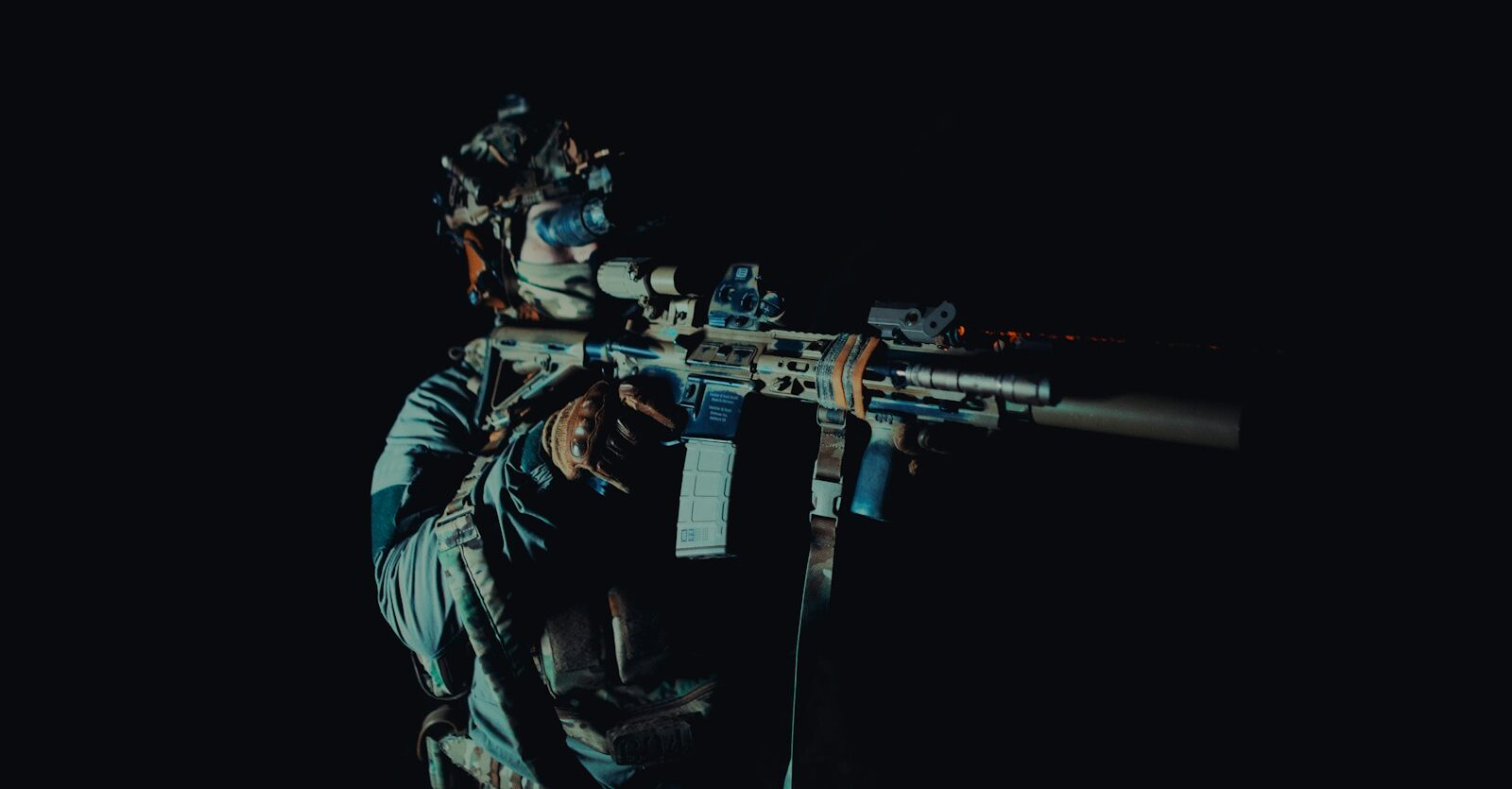 a man holding a rifle in the dark