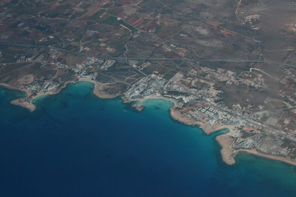 an aerial view of a city next to a body of water
