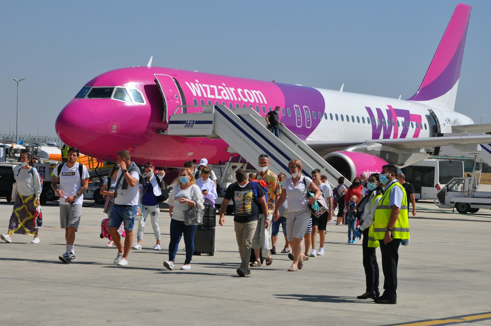 people walking near red and white airplane during daytime
