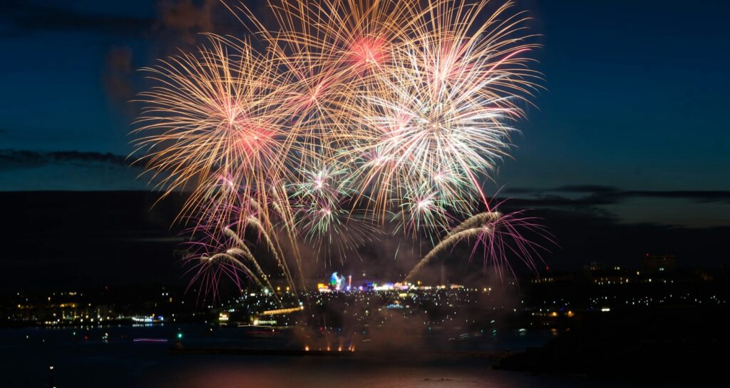 silhouette of two person taking photo of fireworks