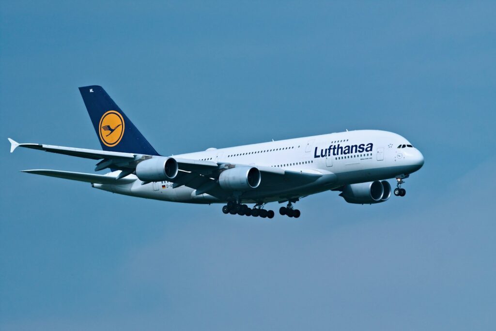 Lufthansa airplane flying in a clear blue sky.