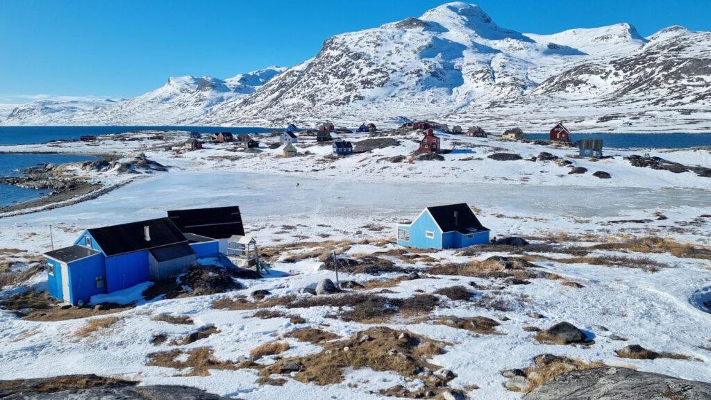 a group of small houses sitting on top of a snow covered field