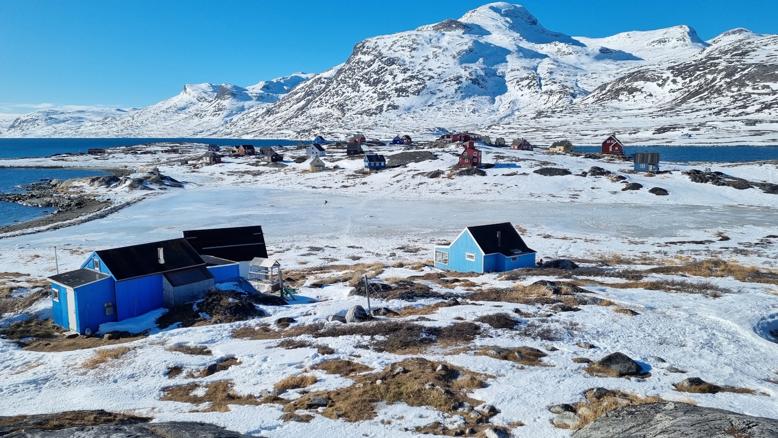 a group of small houses sitting on top of a snow covered field