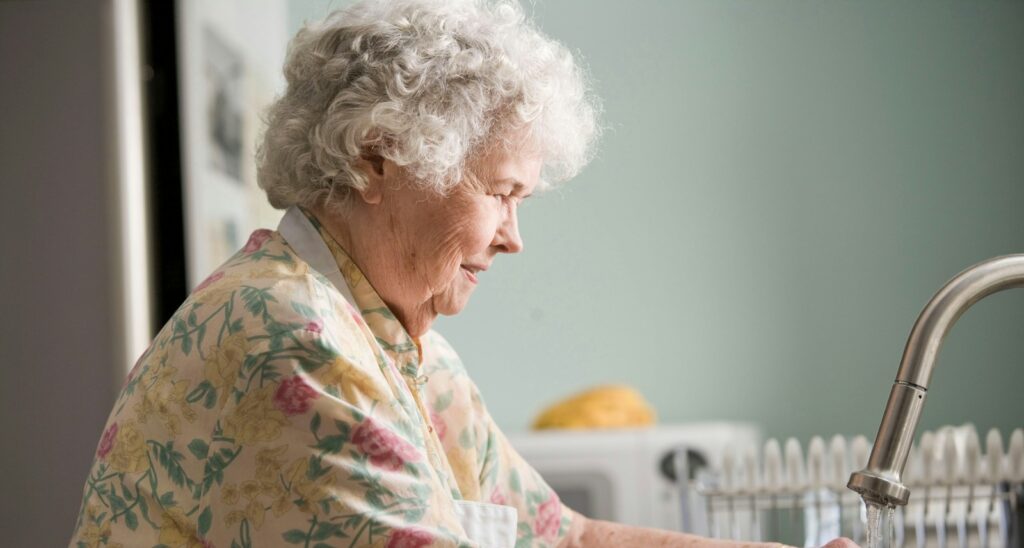 woman in yellow and green floral shirt holding white ceramic mug