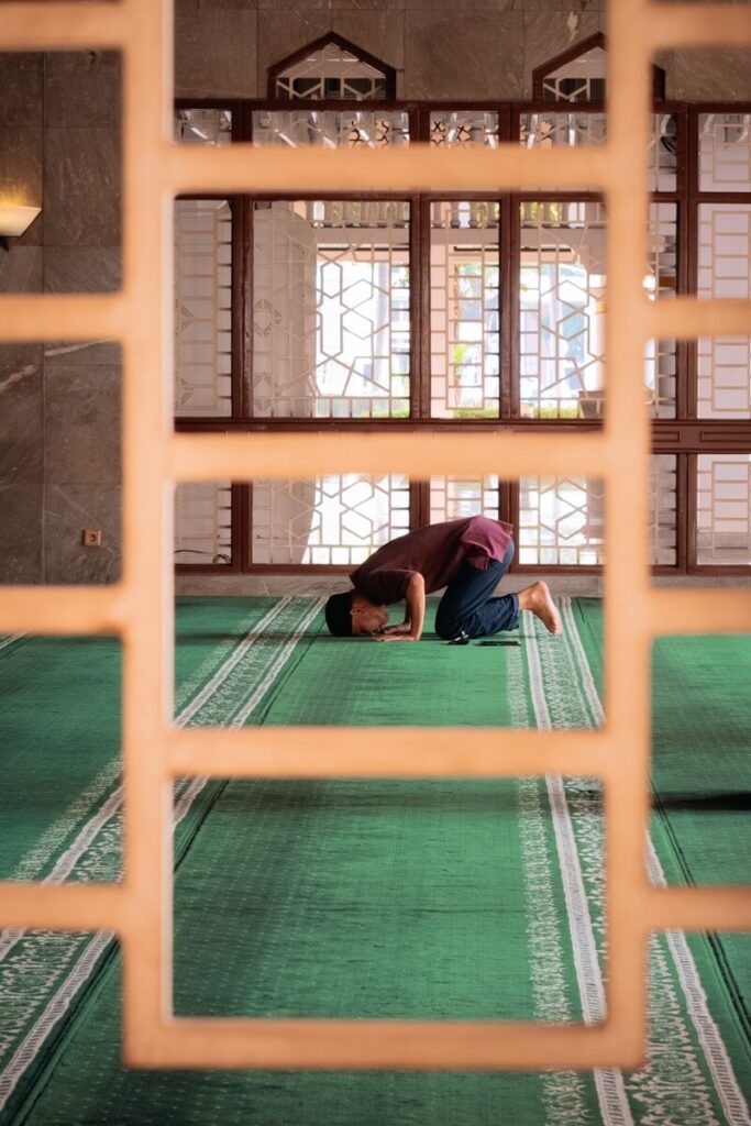 A person is praying in a mosque.
