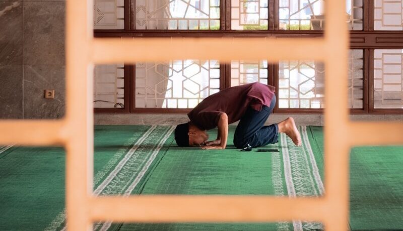 A person is praying in a mosque.