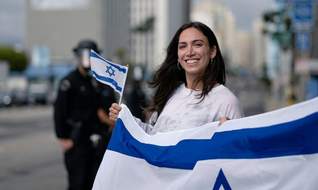 woman in white and blue long sleeve shirt holding blue and white flag