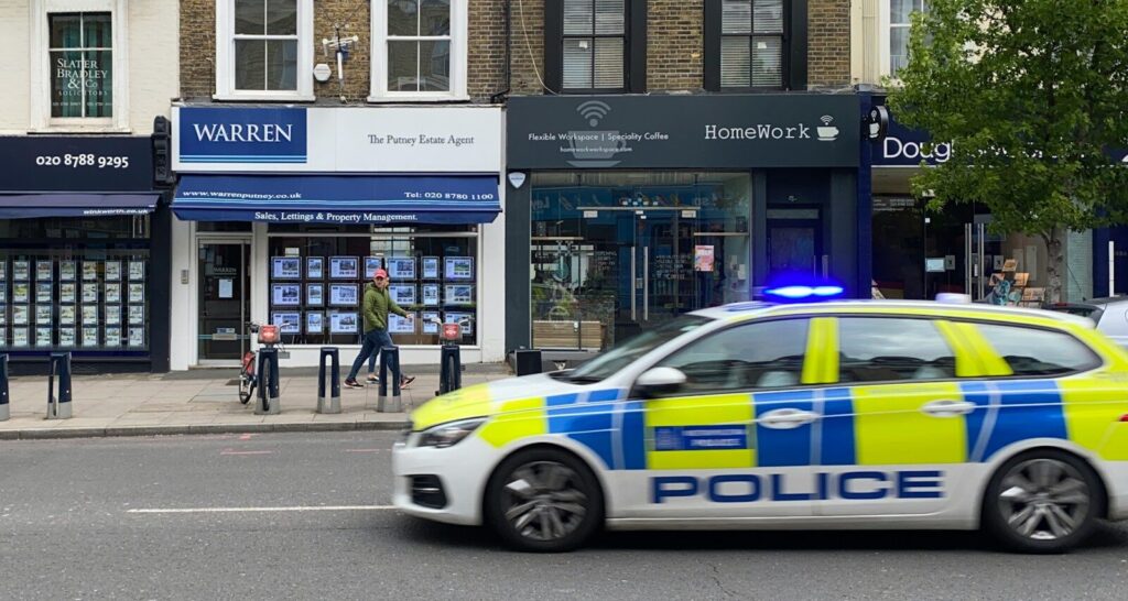 white and blue police car parked in front of building during daytime